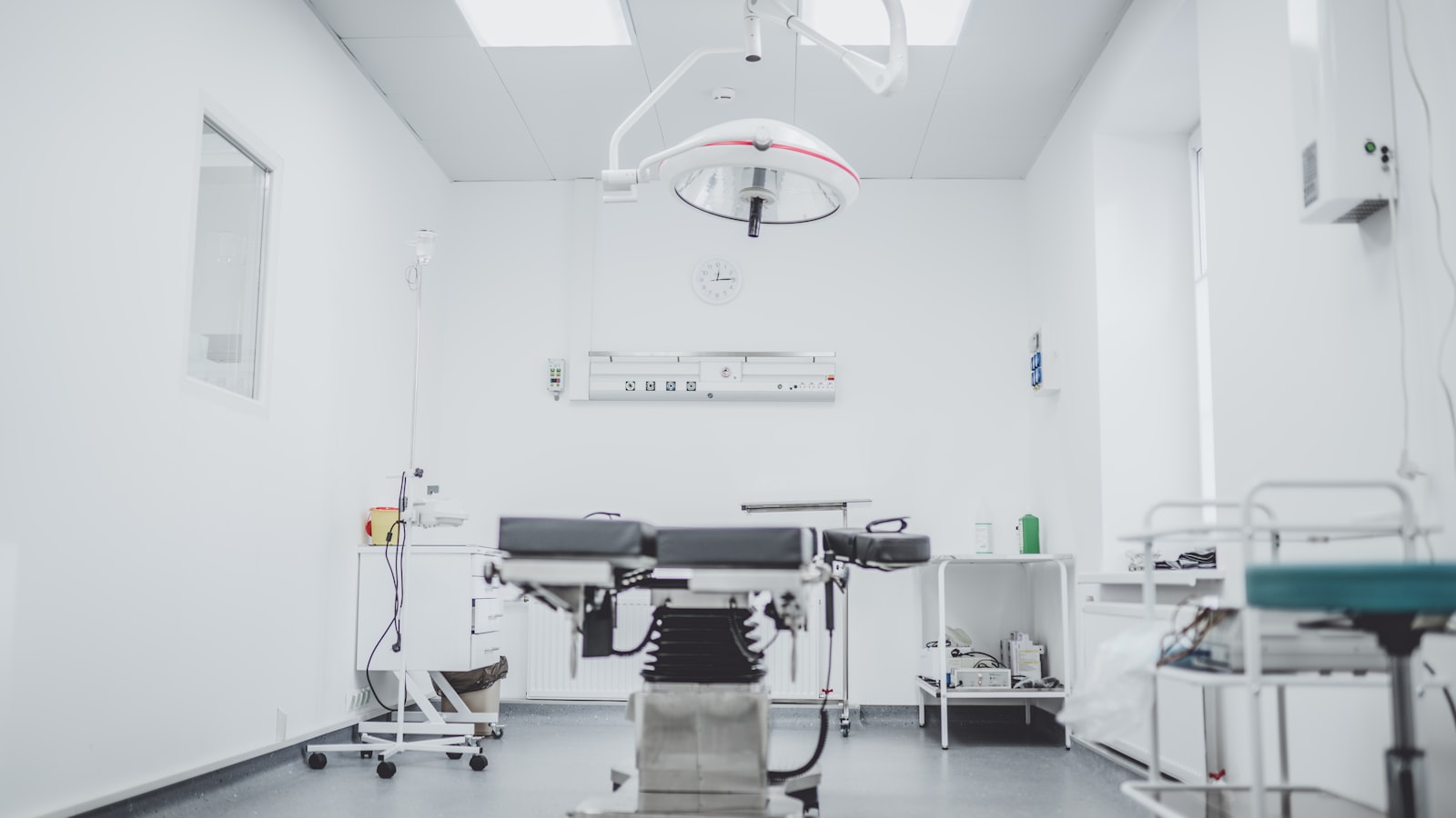 Empty veterinary operating room with a surgical table and overhead exam light